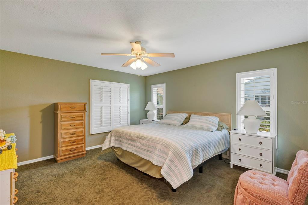 11447 Southwest 69th Circle Ocala, FL 34476 - Photo 15 of 32 a bedroom with a bed and a chandelier