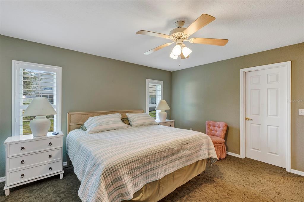 11447 Southwest 69th Circle Ocala, FL 34476 - Photo 16 of 32 a bedroom with a bed and a chandelier