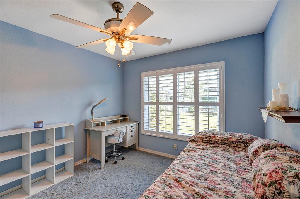 11447 Southwest 69th Circle Ocala, FL 34476 - Photo 19 of 32 a bedroom with a bed and a chandelier