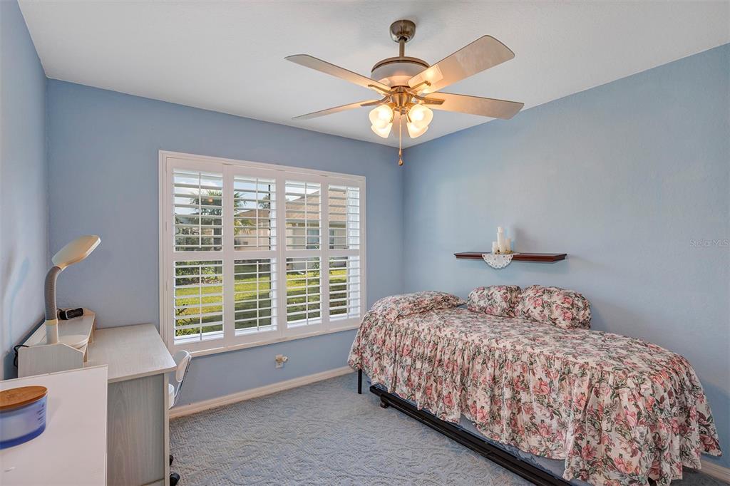11447 Southwest 69th Circle Ocala, FL 34476 - Photo 20 of 32 a bedroom with a bed and a chandelier
