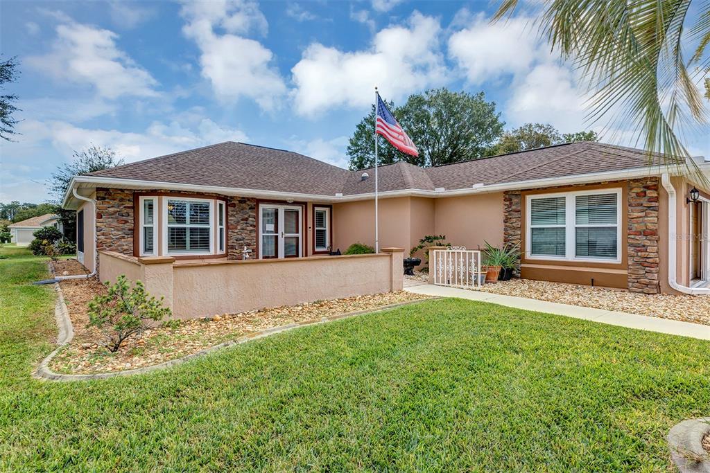 11447 Southwest 69th Circle Ocala, FL 34476 - Photo 2 of 32 a front view of a house with a garden