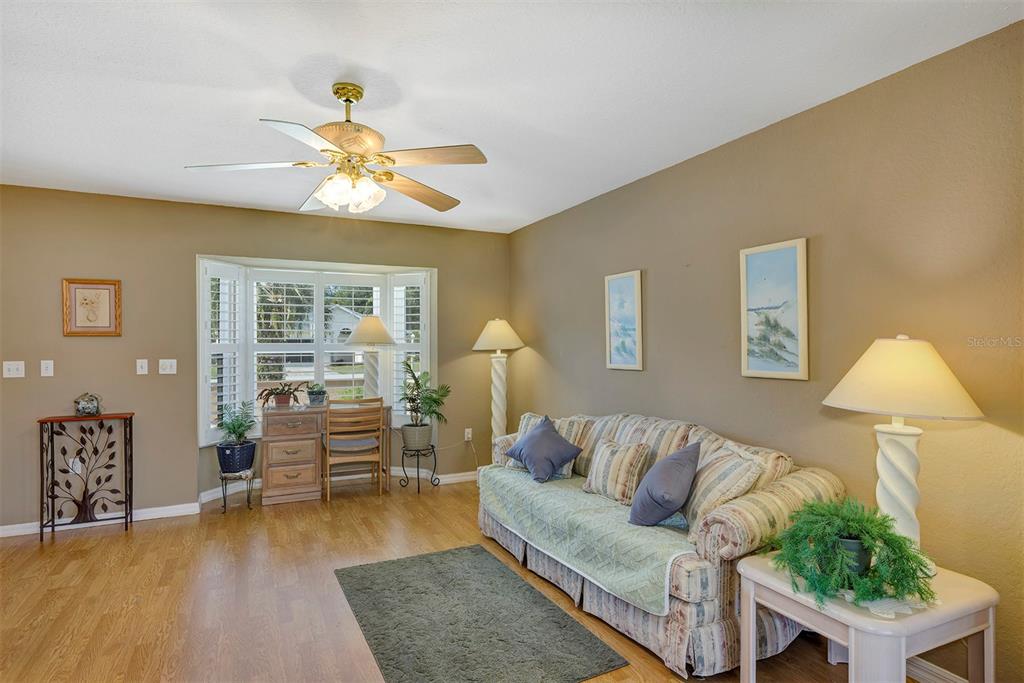 11447 Southwest 69th Circle Ocala, FL 34476 - Photo 22 of 32 a living room with furniture and a wooden floor