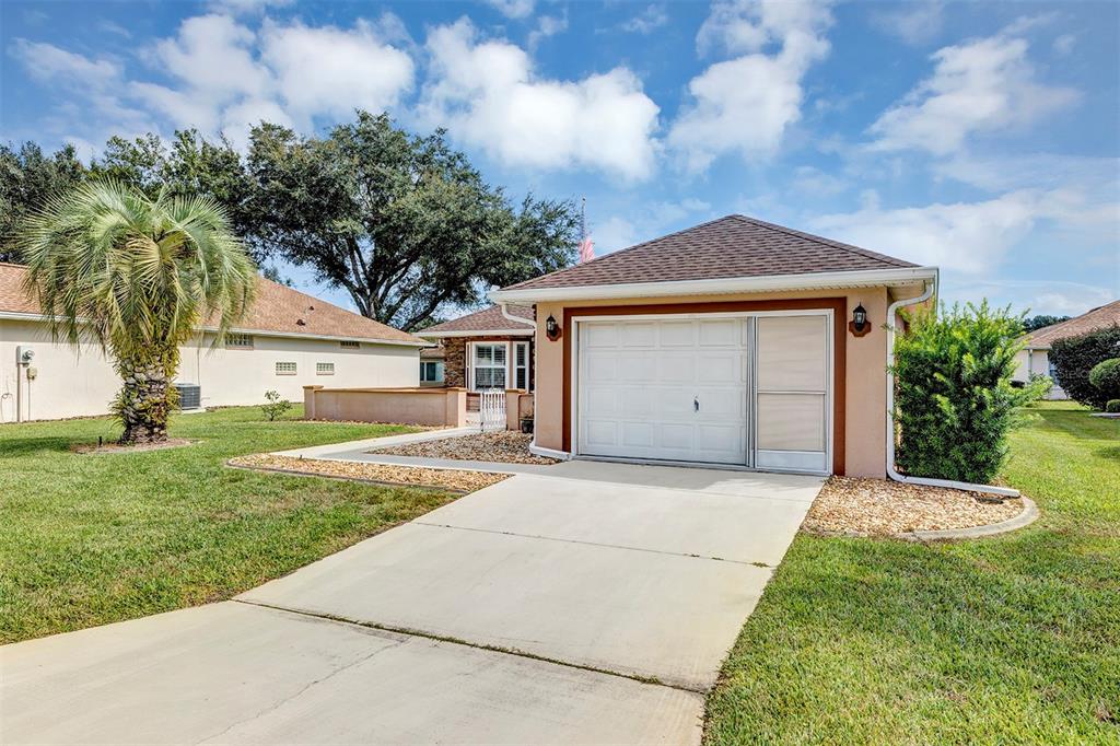 11447 Southwest 69th Circle Ocala, FL 34476 - Photo 31 of 32 a front view of a house with a garden