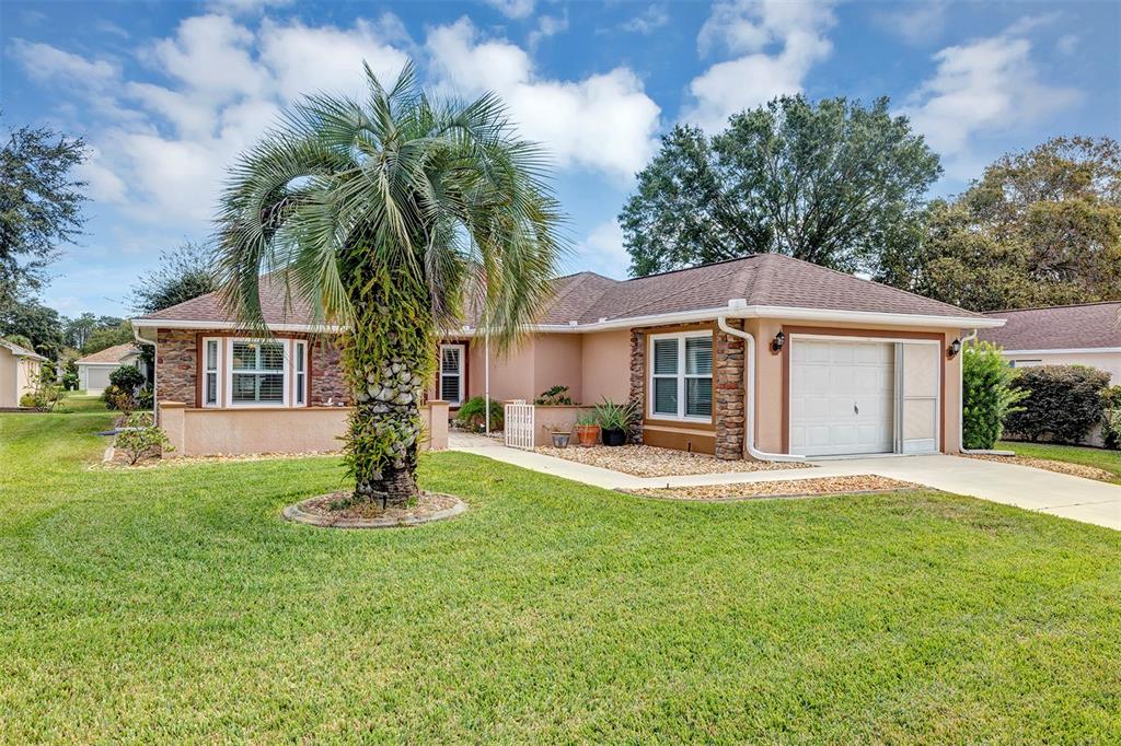 11447 Southwest 69th Circle Ocala, FL 34476 - Photo 32 of 32 a front view of a house with a garden and trees