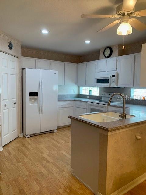 11447 Southwest 69th Circle Ocala, FL 34476 - Photo 6 of 32 a kitchen with kitchen island a sink stainless steel appliances and cabinets