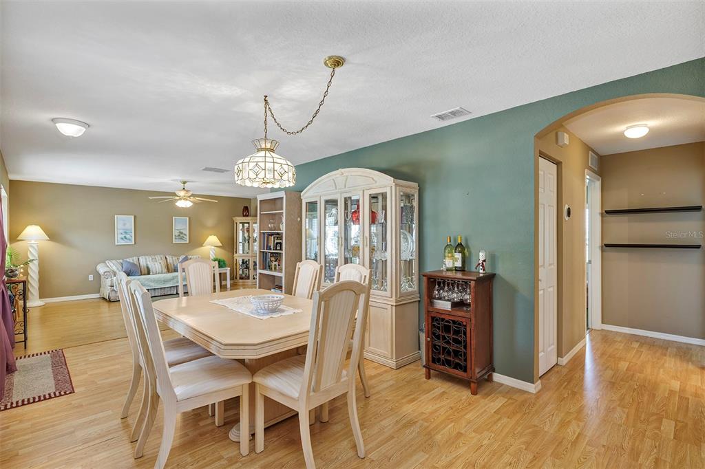 11447 Southwest 69th Circle Ocala, FL 34476 - Photo 9 of 32 a view of a dining room with furniture wooden floor and chandelier