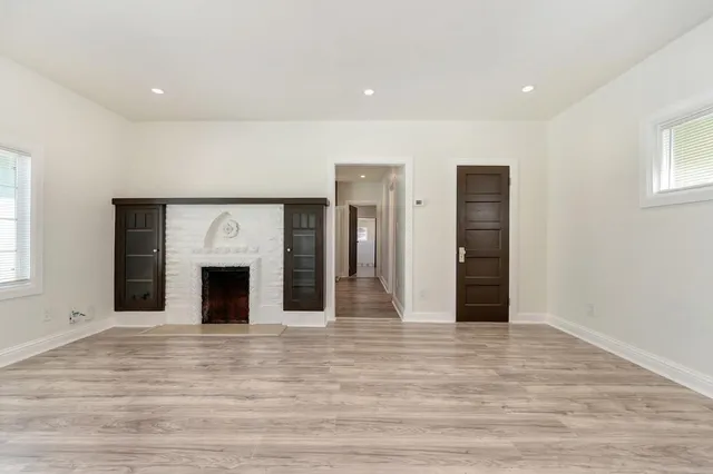 a view of empty room with wooden floor