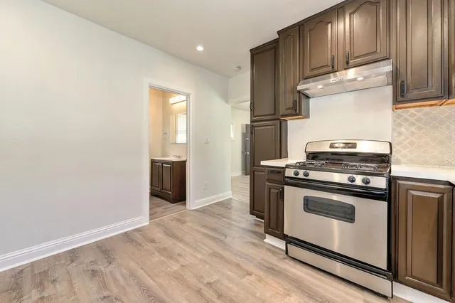 a kitchen with granite countertop wooden floors and stainless steel appliances
