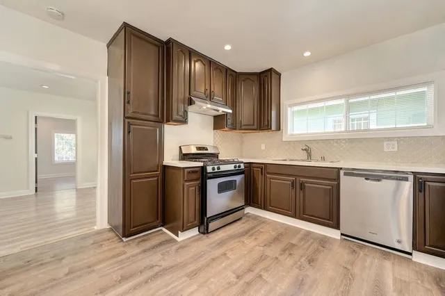 a kitchen with stainless steel appliances granite countertop a refrigerator and a stove top oven