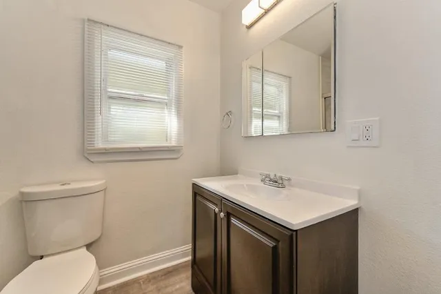 a bathroom with a sink toilet and mirror
