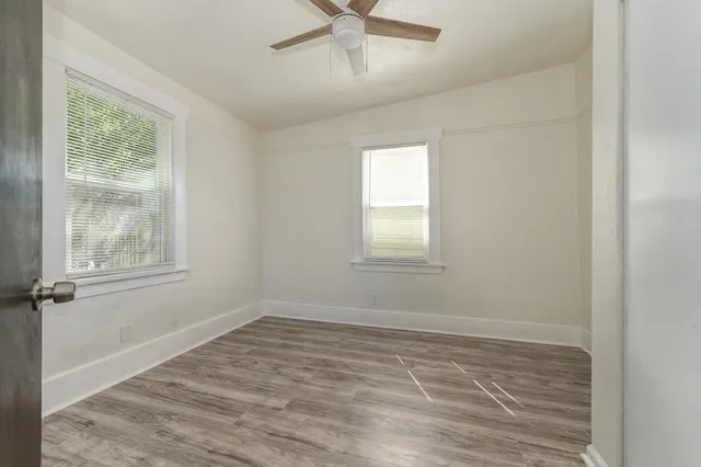 an empty room with a window and ceiling fan