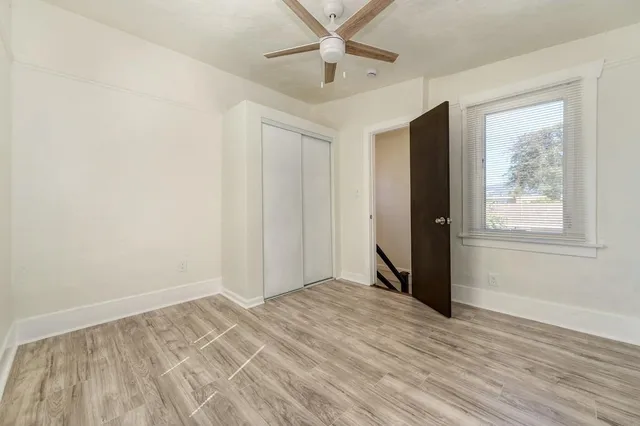 an empty room with wooden floor and windows