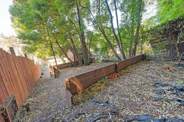a view of a yard with wooden fence