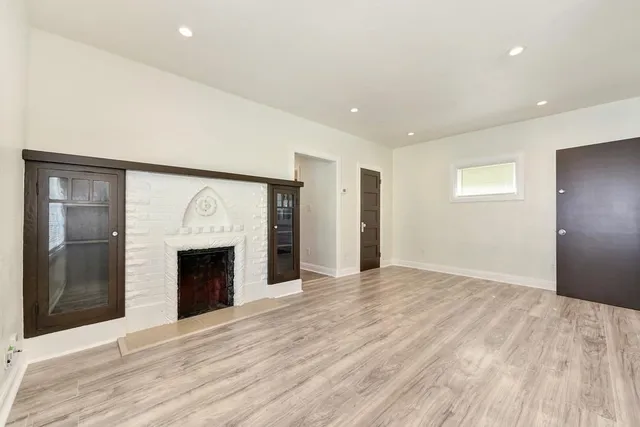 a view of an empty room with a fireplace and a window