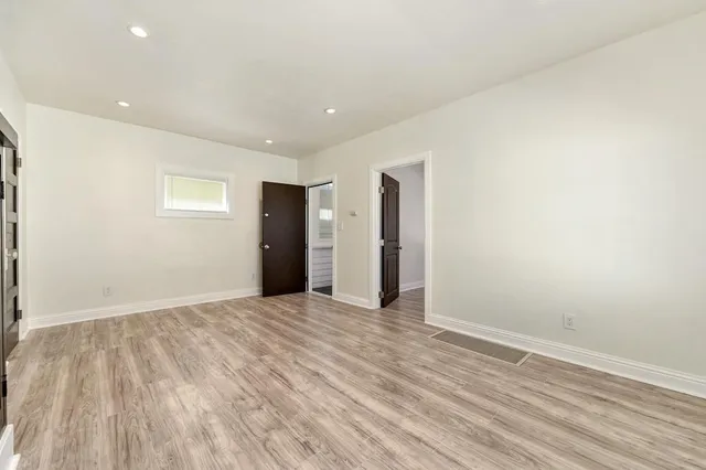 a view of an empty room with wooden floor