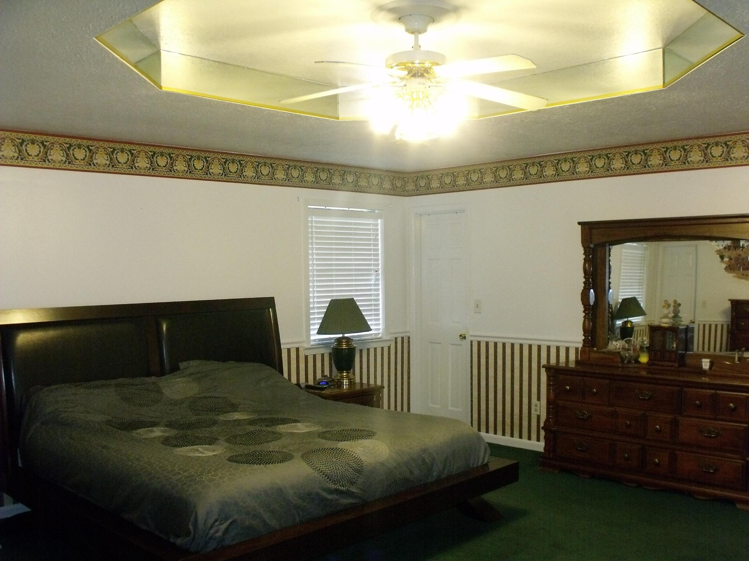 6047 Eden Square Crestview, FL 32539 - Photo 11 of 22 a bedroom with a bed and a chandelier