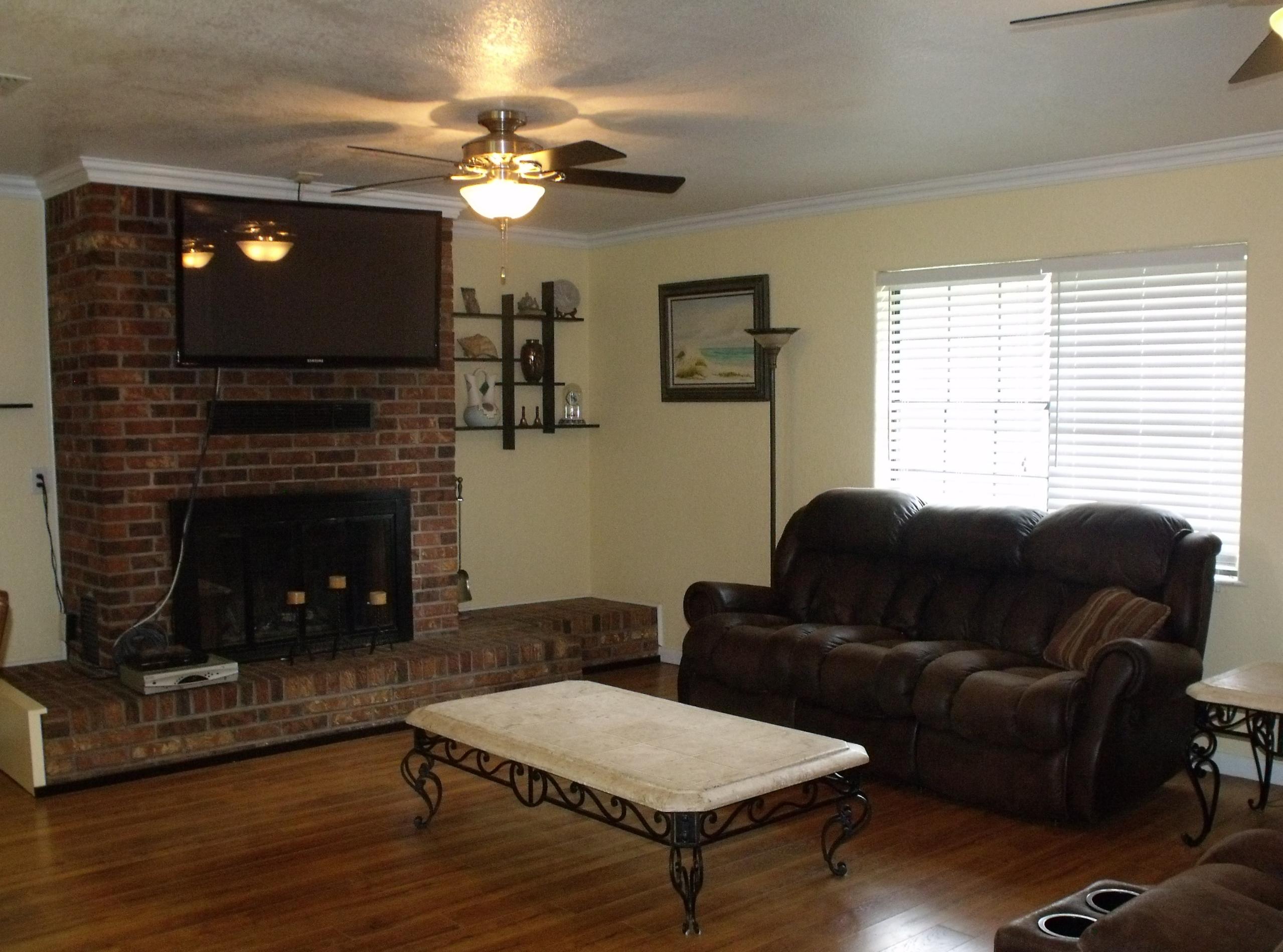 6047 Eden Square Crestview, FL 32539 - Photo 12 of 22 a living room with furniture a fireplace and a flat screen tv