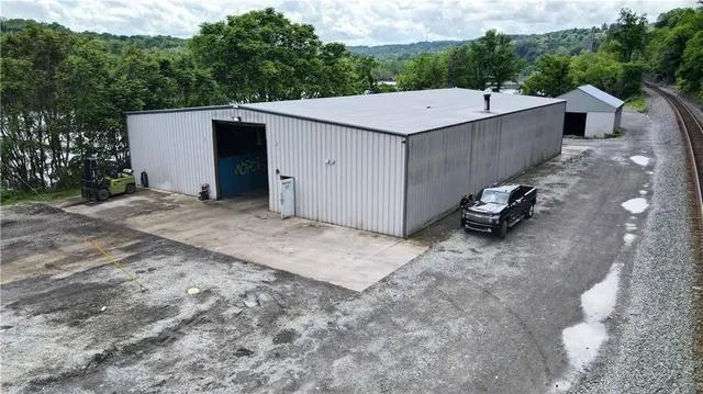 a view of a white house with a yard and large tree
