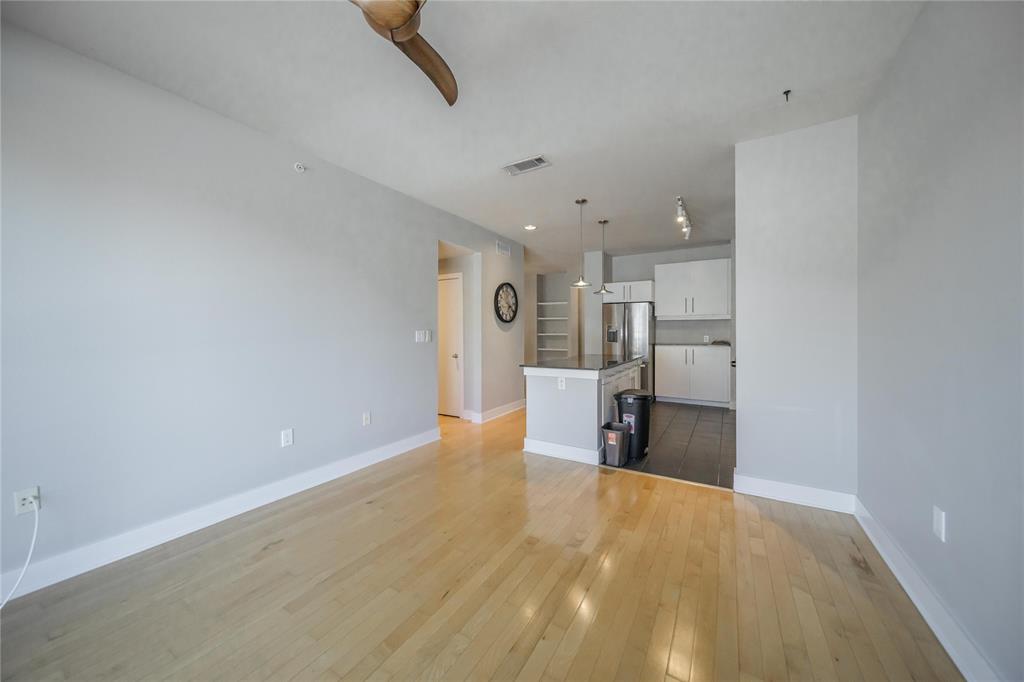 4414 Cedar Springs Road, Unit 214 Dallas, TX 75219 - Photo 11 of 29 Unfurnished living room with dark wood-style flooring and baseboards