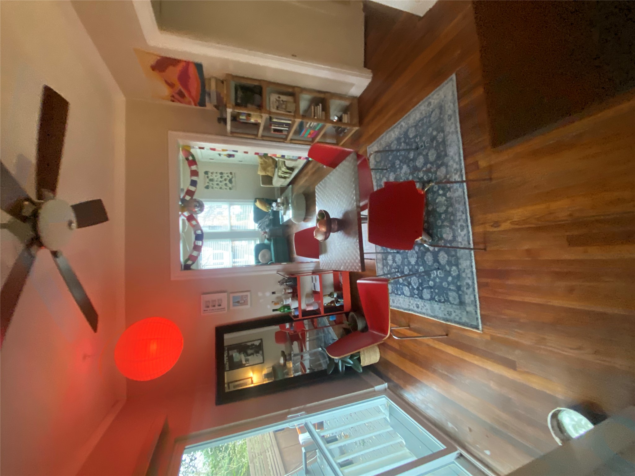3010 Fruth Street, Unit A Austin, TX 78705 - Photo 23 of 39 Dining area featuring wood-finish flooring, a ceiling fan with integrated lighting, and a wide cased opening to an additional living space