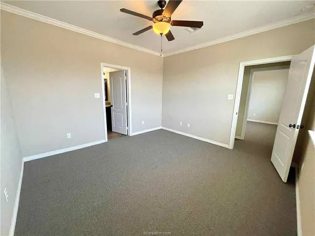 an empty room with closet and a chandelier fan