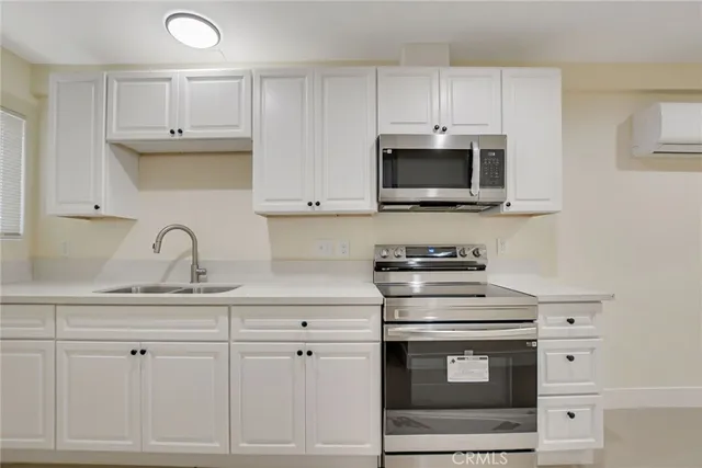 a kitchen with cabinets stainless steel appliances a sink and a counter top