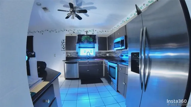 a kitchen with stainless steel appliances granite countertop a refrigerator a stove and a sink