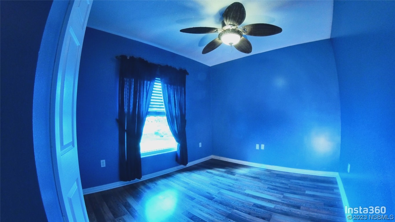 213 Falcon Avenue Edgewater, FL 32141 - Photo 29 of 44 a view of an empty room with a window and wooden floor
