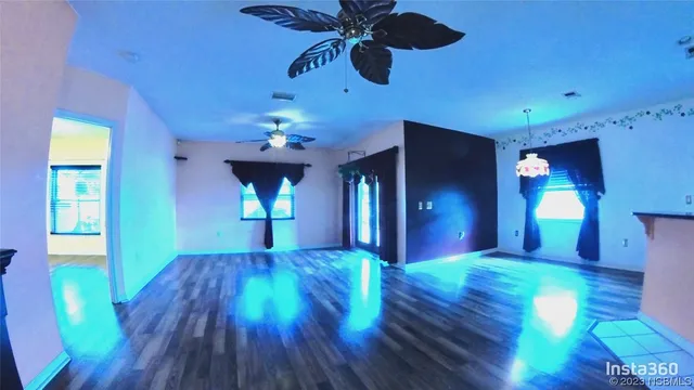 a view of a room with a chandelier and wooden floor