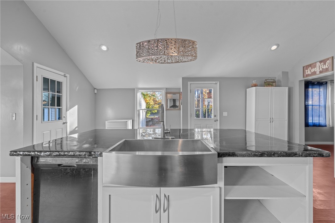 5865 Ruple Parkway Brook Park, OH 44142 - Photo 12 of 45 Kitchen with lofted ceiling, dark wood-type flooring, hanging light fixtures, sink, and white cabinetry