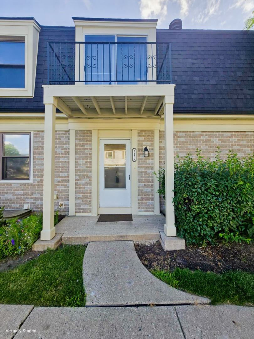 2120 North Ginger Creek Drive, Unit 18D Palatine, IL 60074 - Photo 1 of 1 a view of a brick house with plants