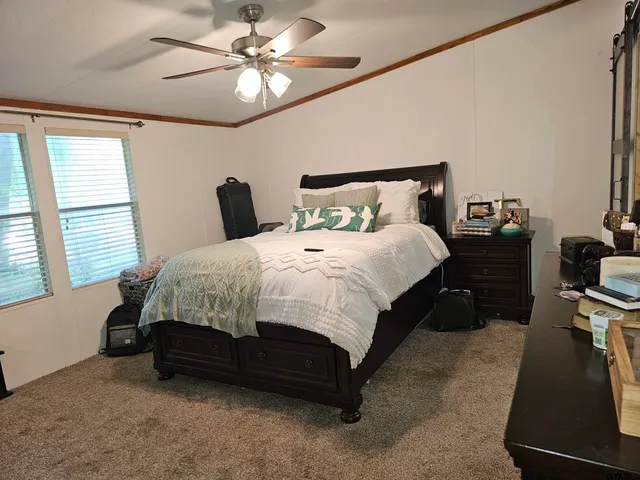 a bedroom with a bed dresser and a window