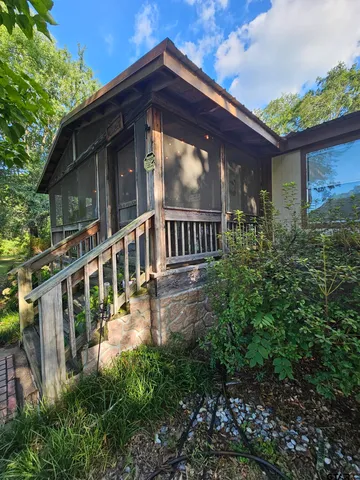 a view of house with a yard and balcony