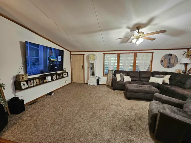 a living room with furniture a chandelier and a flat screen tv