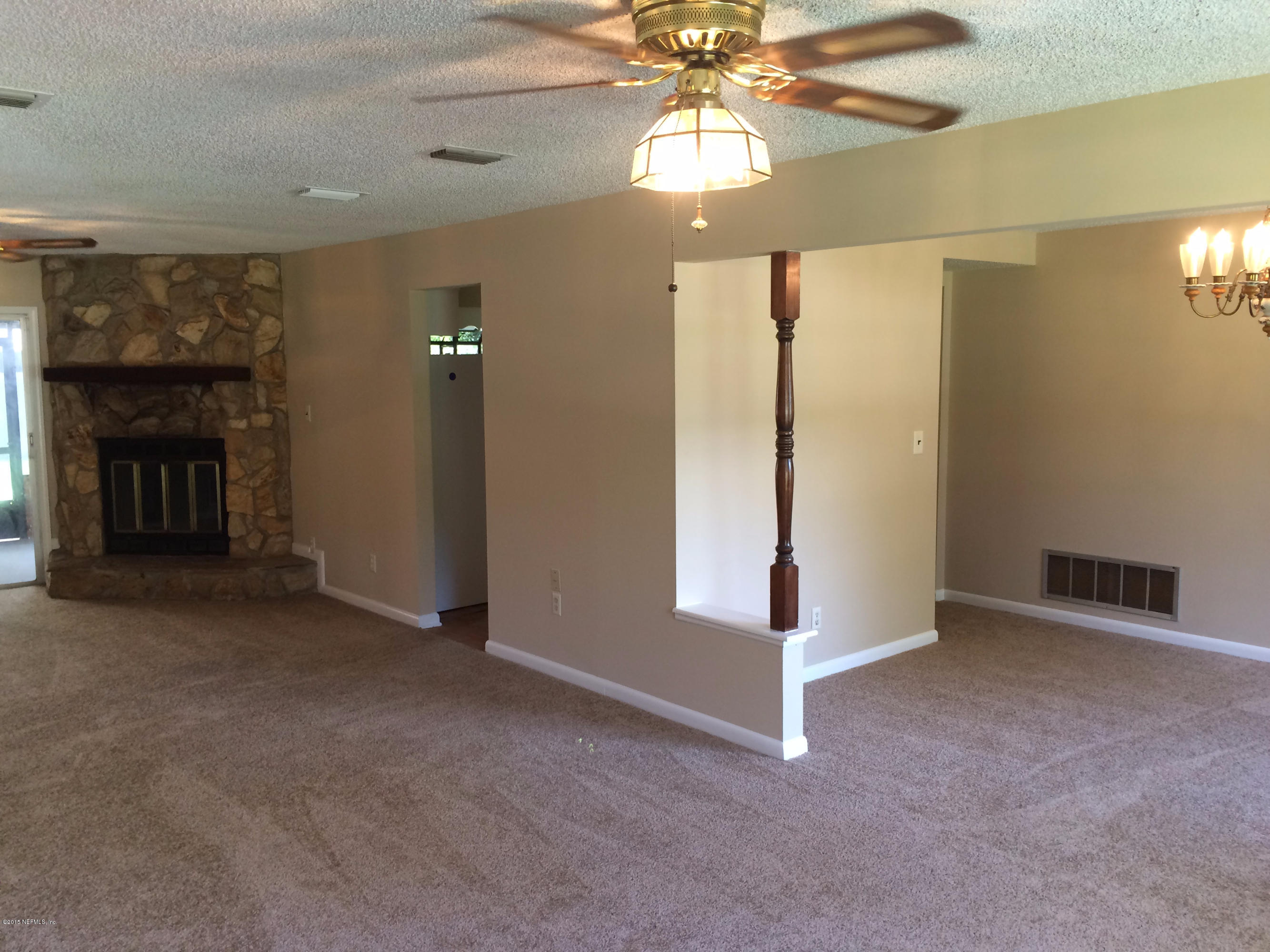 5471 Weaver Road Orange Park, FL 32073 - Photo 8 of 22 an empty room with a fireplace and chandelier fan