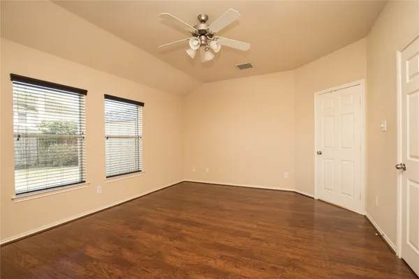 a view of an empty room with a window and a ceiling fan