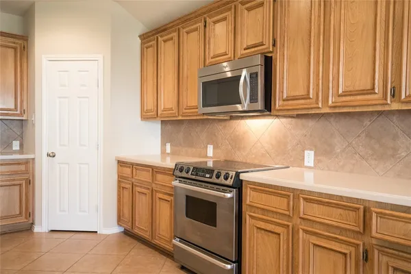 a kitchen with stainless steel appliances granite countertop white cabinets and a stove top oven