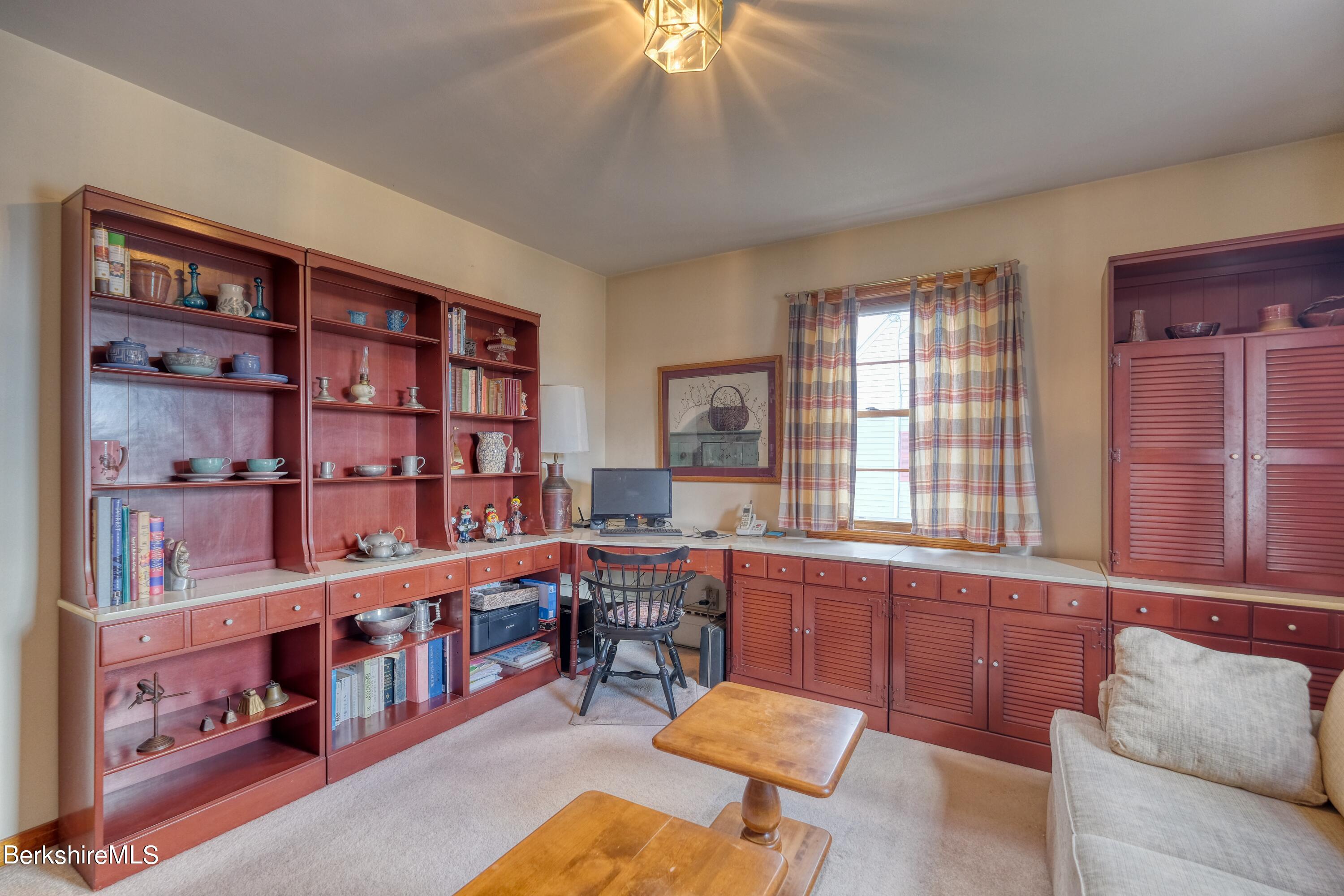 237 Eleanor Road Pittsfield, MA 01201 - Photo 14 of 30 a room with furniture a bookshelf and a window
