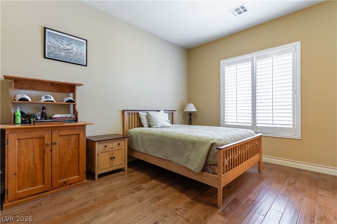 3661 Riley Ann Avenue Las Vegas, NV 89139 - Photo 20 of 42 Hardwood floors and bright windows create a cozy, inviting bedroom retreat.