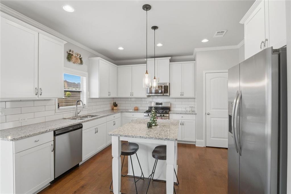 619 Little Bear Loop Canton, GA 30114 - Photo 13 of 39 a kitchen with a sink stainless steel appliances cabinets and a counter top space