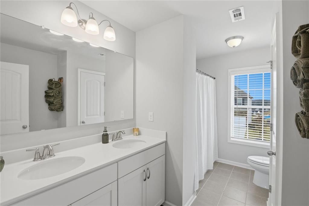 619 Little Bear Loop Canton, GA 30114 - Photo 29 of 39 a bathroom with a toilet a sink and a mirror