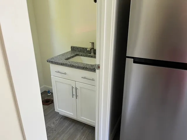 a bathroom with a granite countertop sink and a mirror