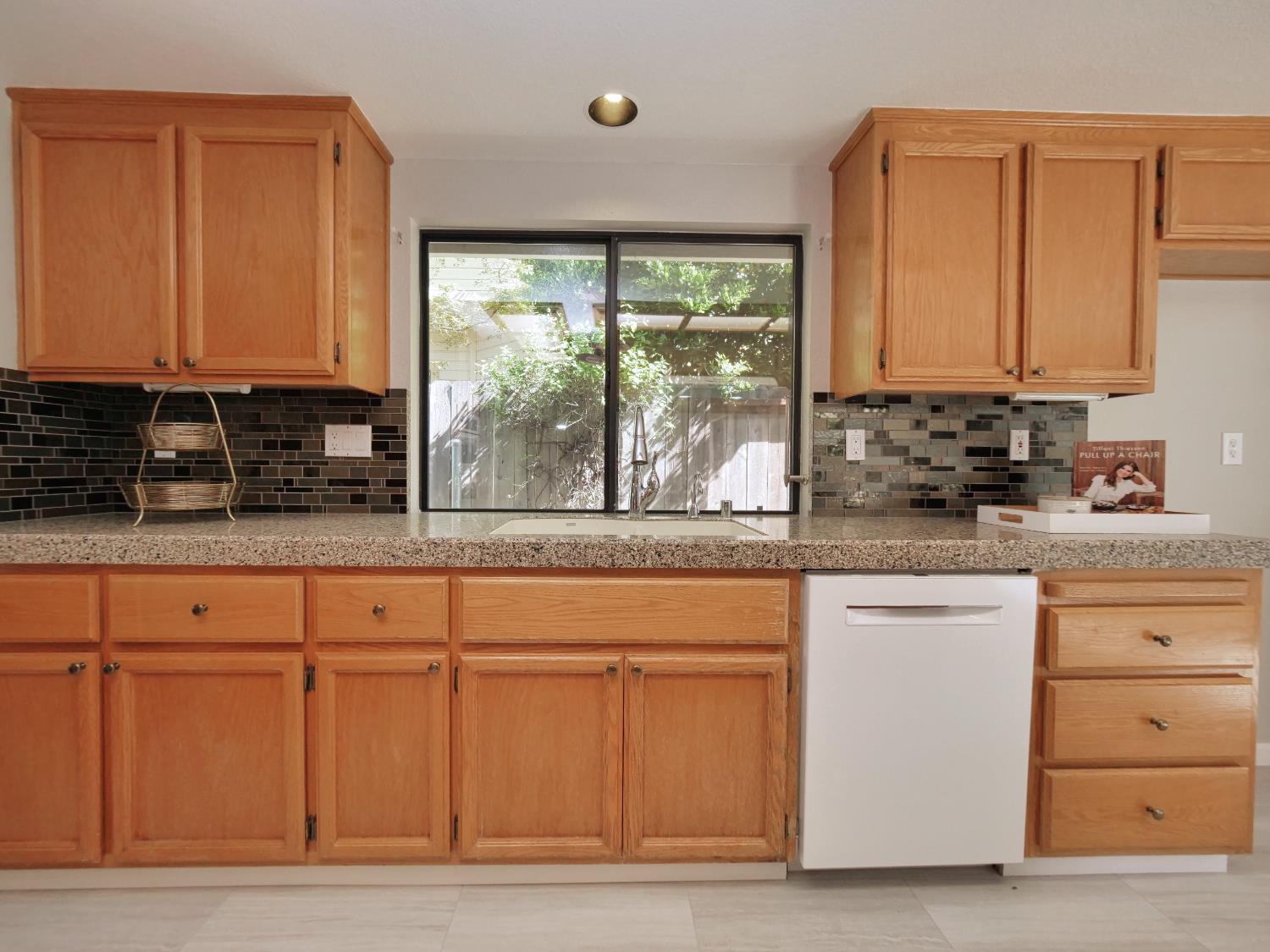 11864 South Carson Way Gold River, CA 95670 - Photo 30 of 69 a kitchen with granite countertop a stove a sink and a microwave