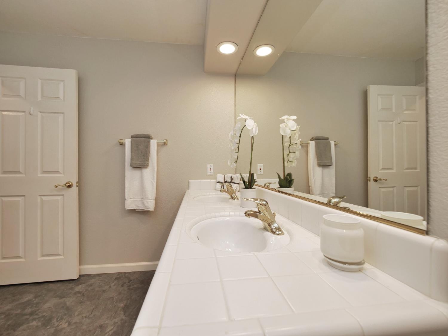 11864 South Carson Way Gold River, CA 95670 - Photo 44 of 69 a spacious bathroom with a double vanity sink a mirror and a bathtub