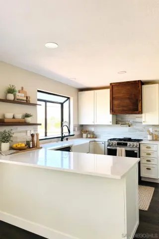 a living room with stainless steel appliances a flat screen tv and a view of kitchen