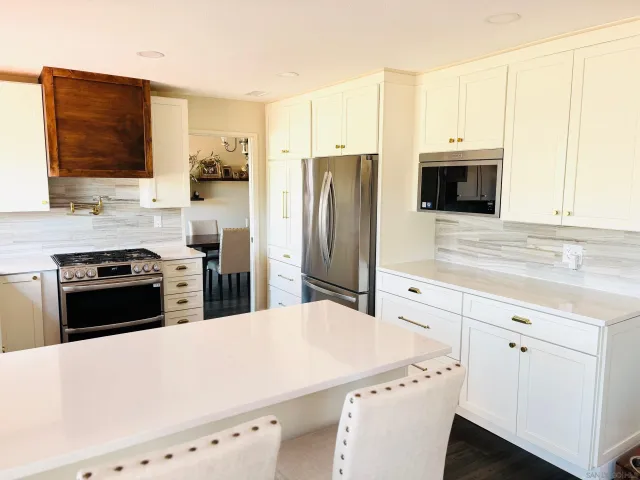 a kitchen with stainless steel appliances a stove microwave and refrigerator