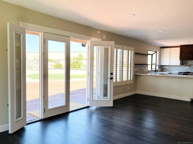 a view of a kitchen with wooden floor and a window