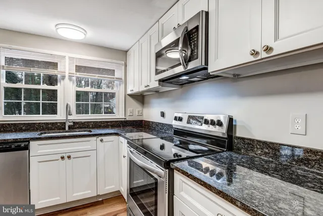 a kitchen with stainless steel appliances granite countertop a stove and a microwave