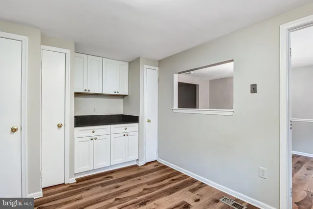 a kitchen with granite countertop white cabinets and stainless steel appliances