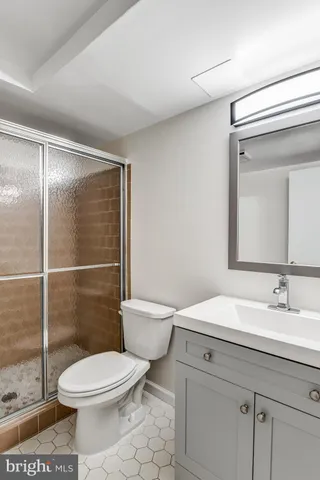a bathroom with a toilet a sink and glass door